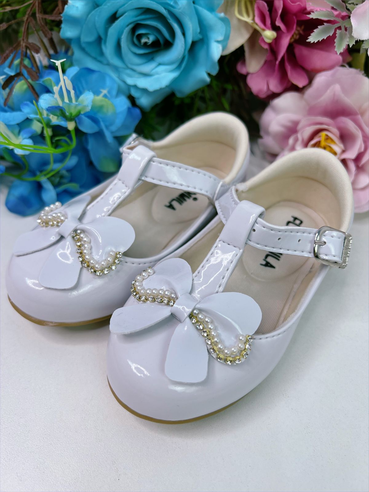 Zapato de charol blanco con lazo, pedrería y perlas