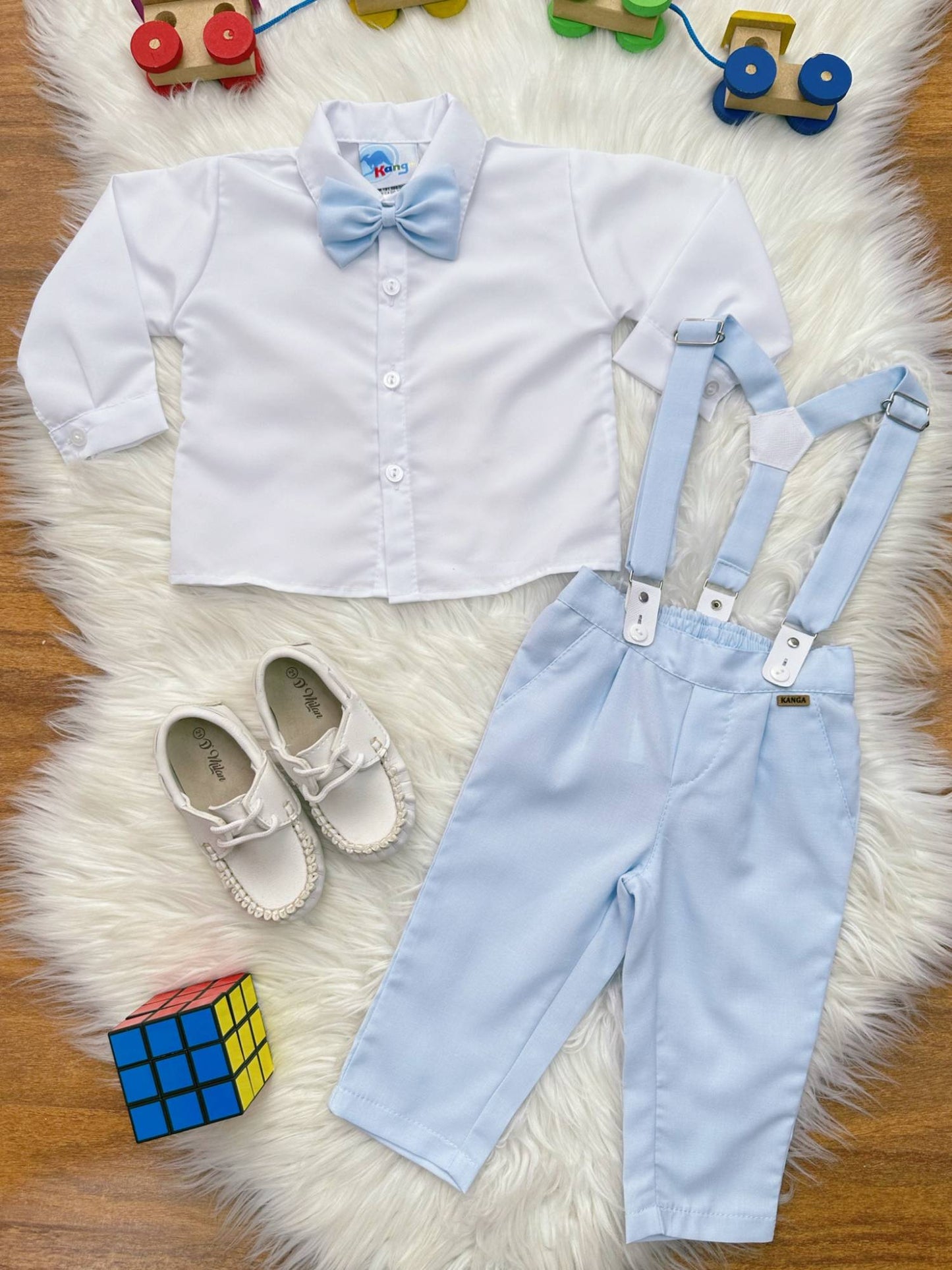 Conjunto social para bebé, camisa blanca, pantalón, corbata y tirantes azules.