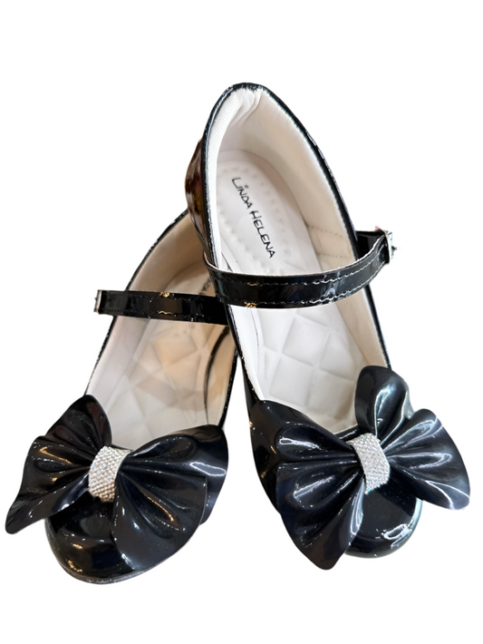 Zapato de tacón de charol negro con lazo y aplique de pedrería