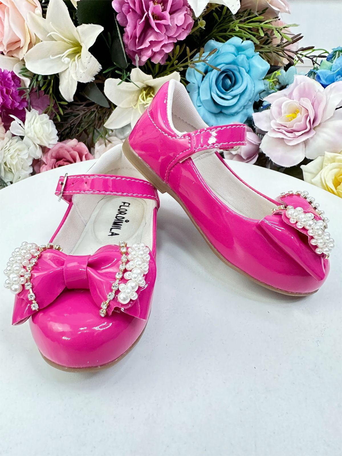 Zapato de charol rosa con lazo, perlas y pedrería
