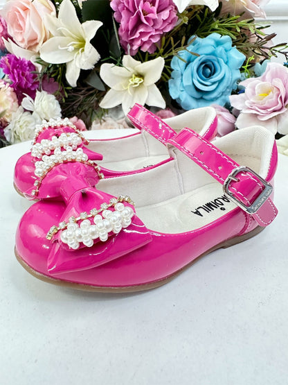 Zapato de charol rosa con lazo, perlas y pedrería