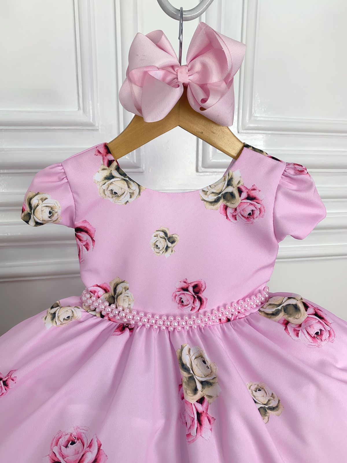 Vestido infantil de primavera con flores rosas y cinturón de perlas