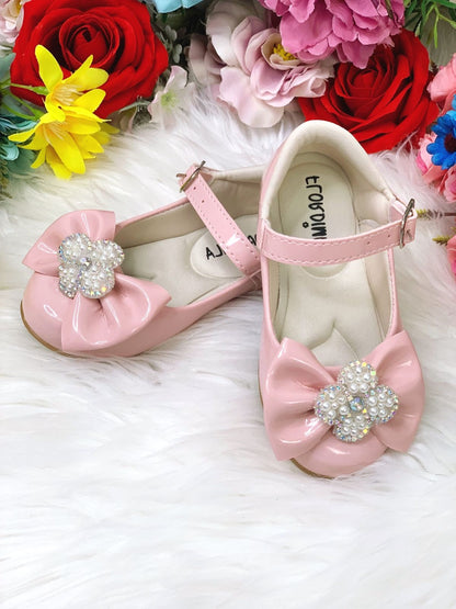 Zapatos de charol rosa con lazo y flor, pedrería y perlas 