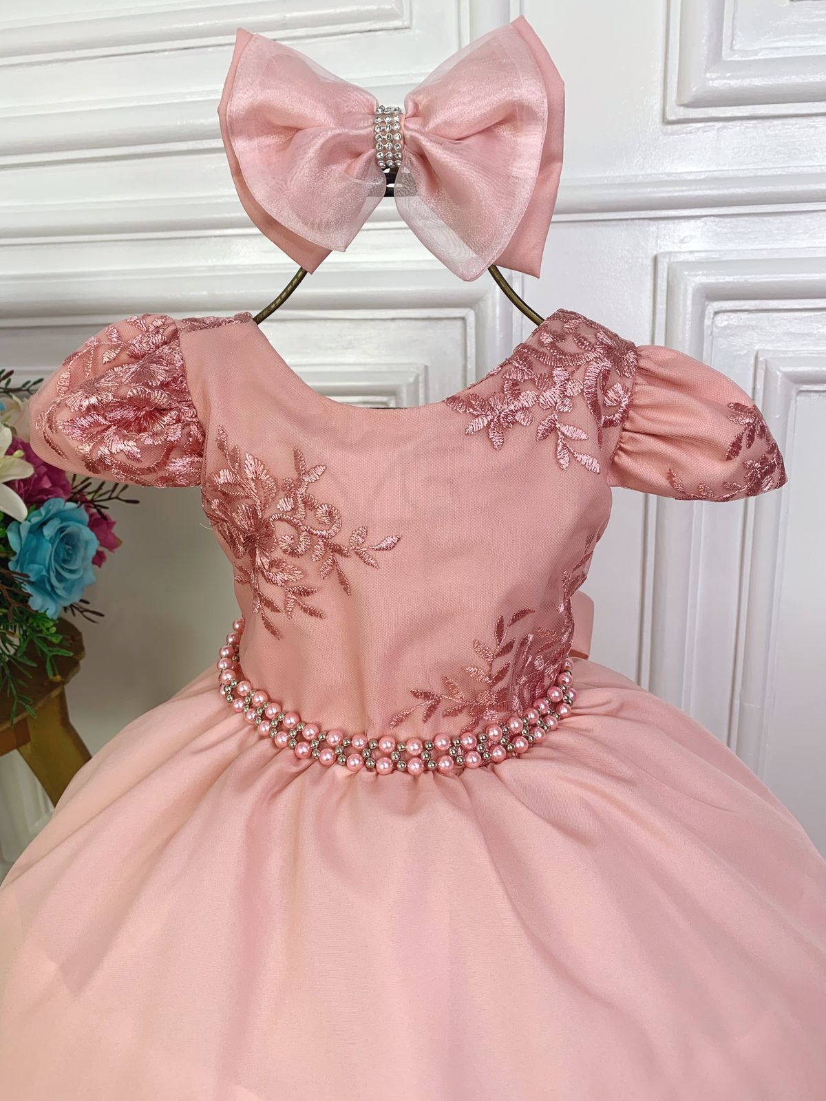Vestido infantil rosa con encaje, cinturón de perlas y lazo