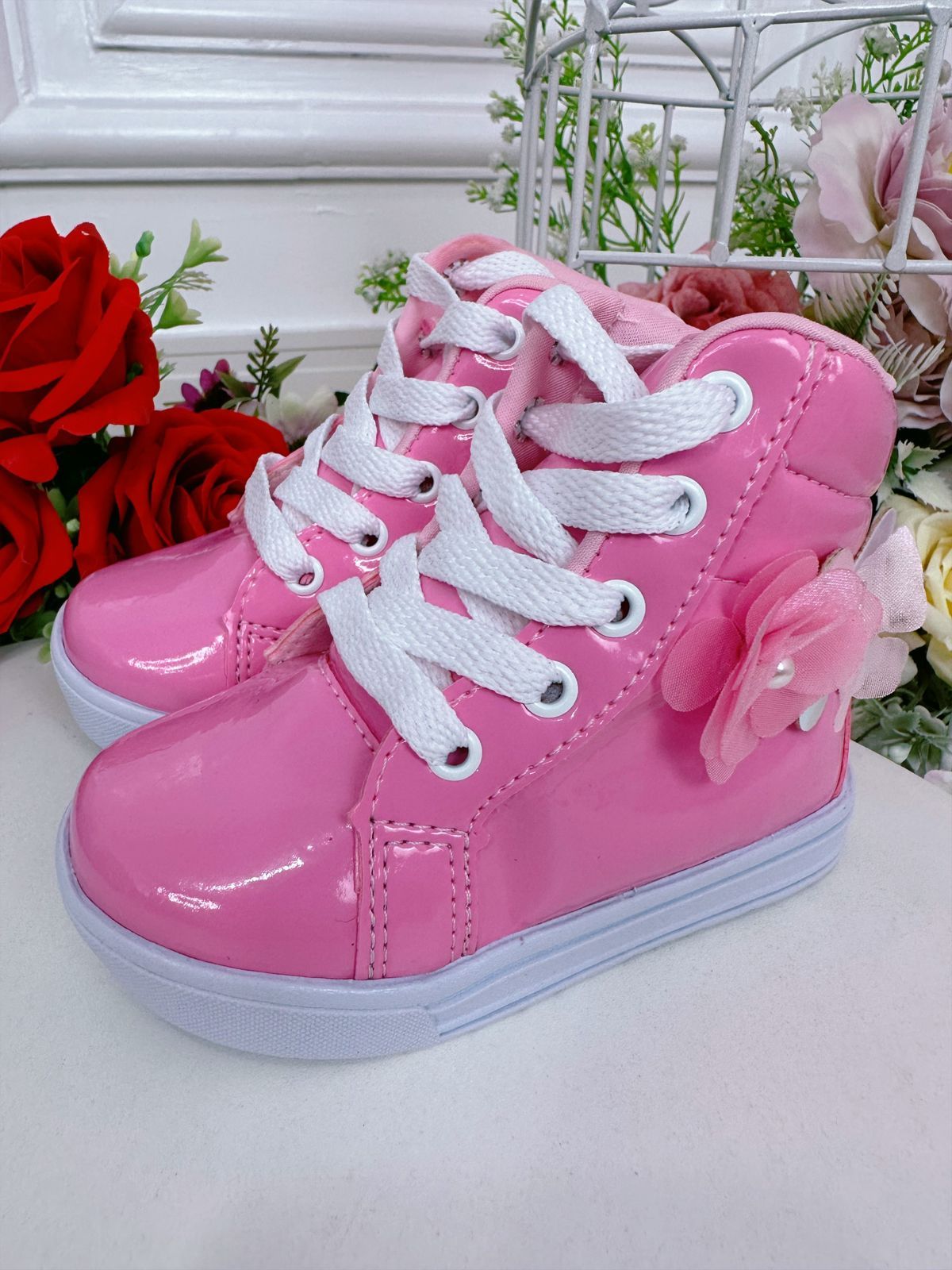 Botines infantiles con flores de mariposa y cordones en color rosa chicle