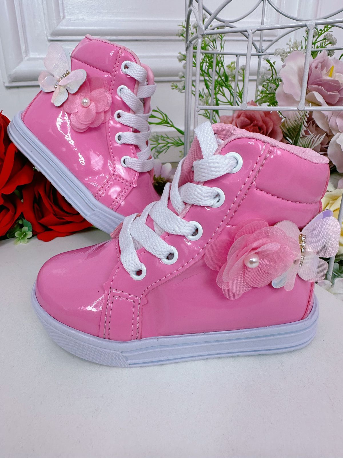 Botines infantiles con flores de mariposa y cordones en color rosa chicle