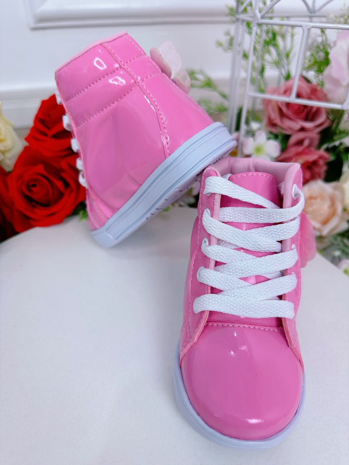 Botines infantiles con flores de mariposa y cordones en color rosa chicle