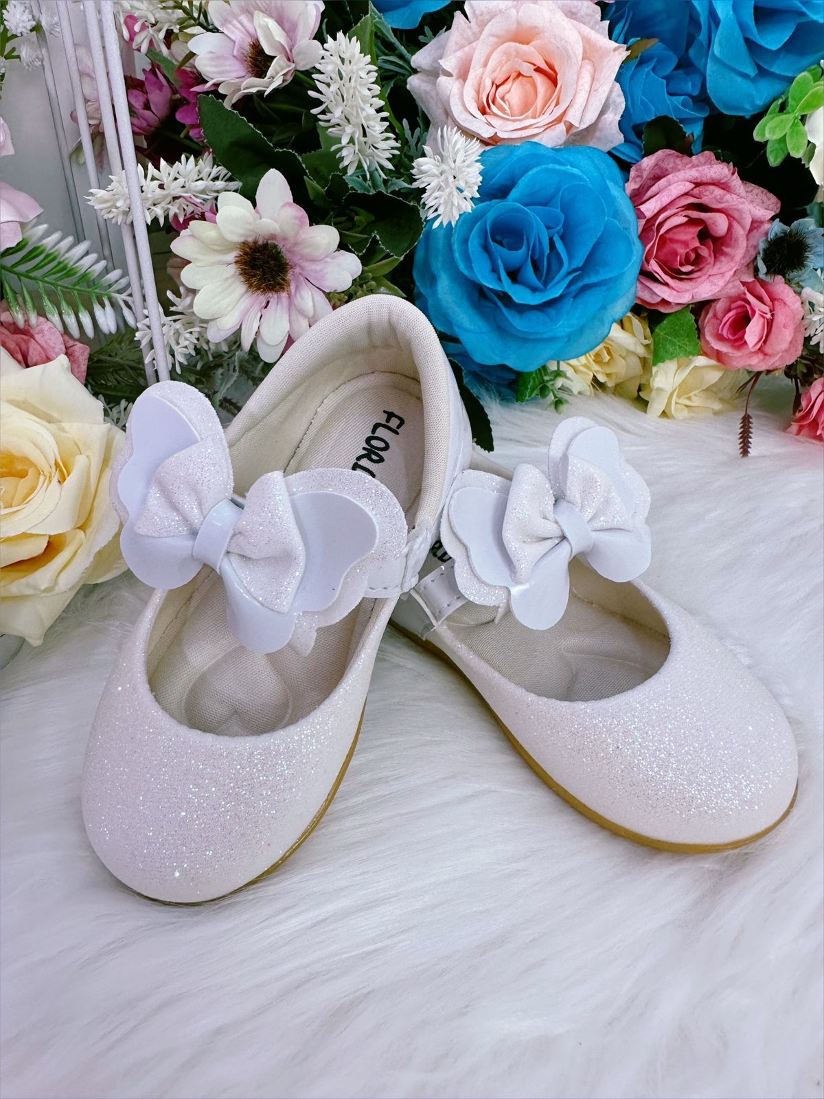 Zapatos de bebé blancos con lazo y aplique de purpurina 