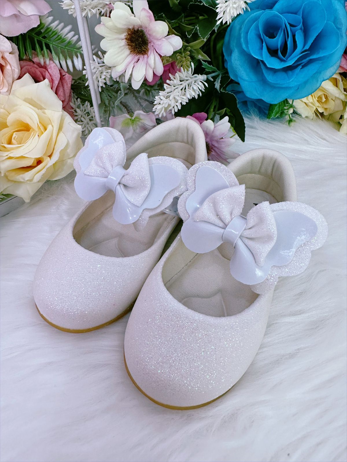 Zapatos de bebé blancos con lazo y aplique de purpurina 