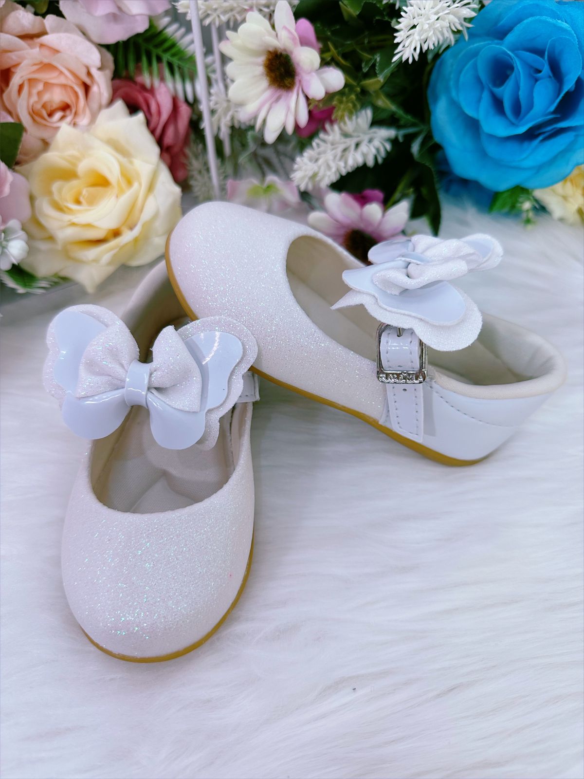 Zapatos de bebé blancos con lazo y aplique de purpurina 
