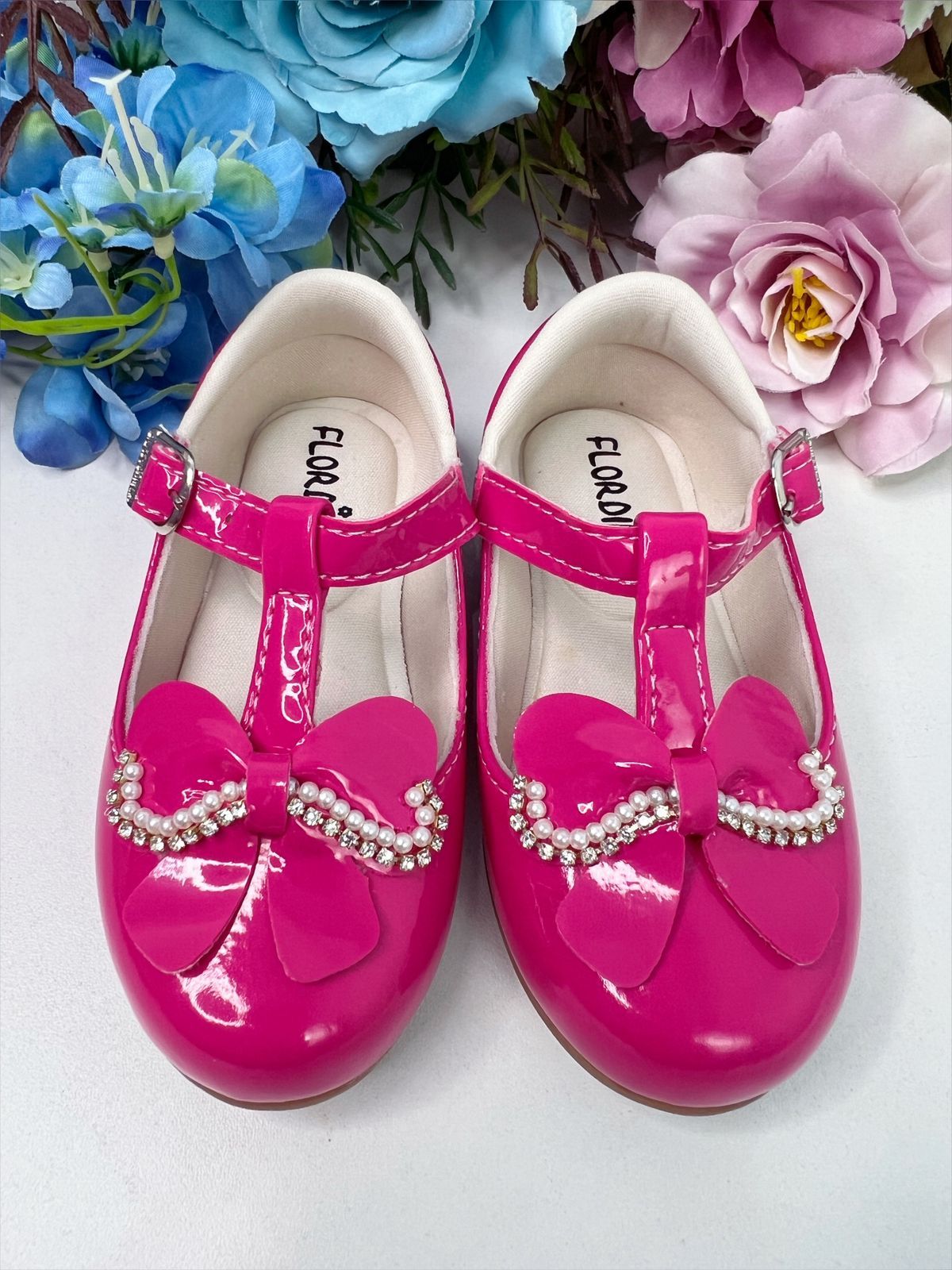 Zapato de charol rosa con lazo, pedrería y perlas