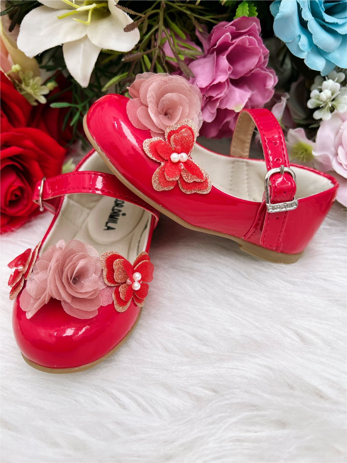 Zapato de charol rojo con aplique de flor de mariposa