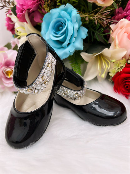 Zapato negro brillante con perlas y pedrería