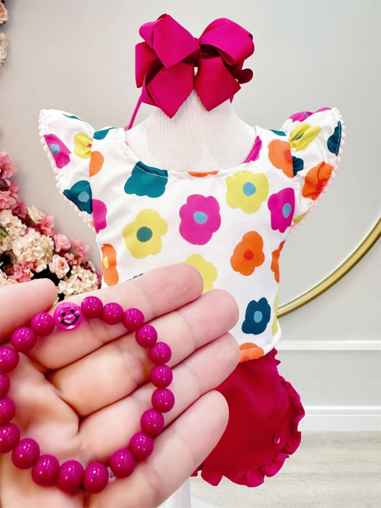 Conjunto floral blanco para niña con pantalón corto rosa y pulsera