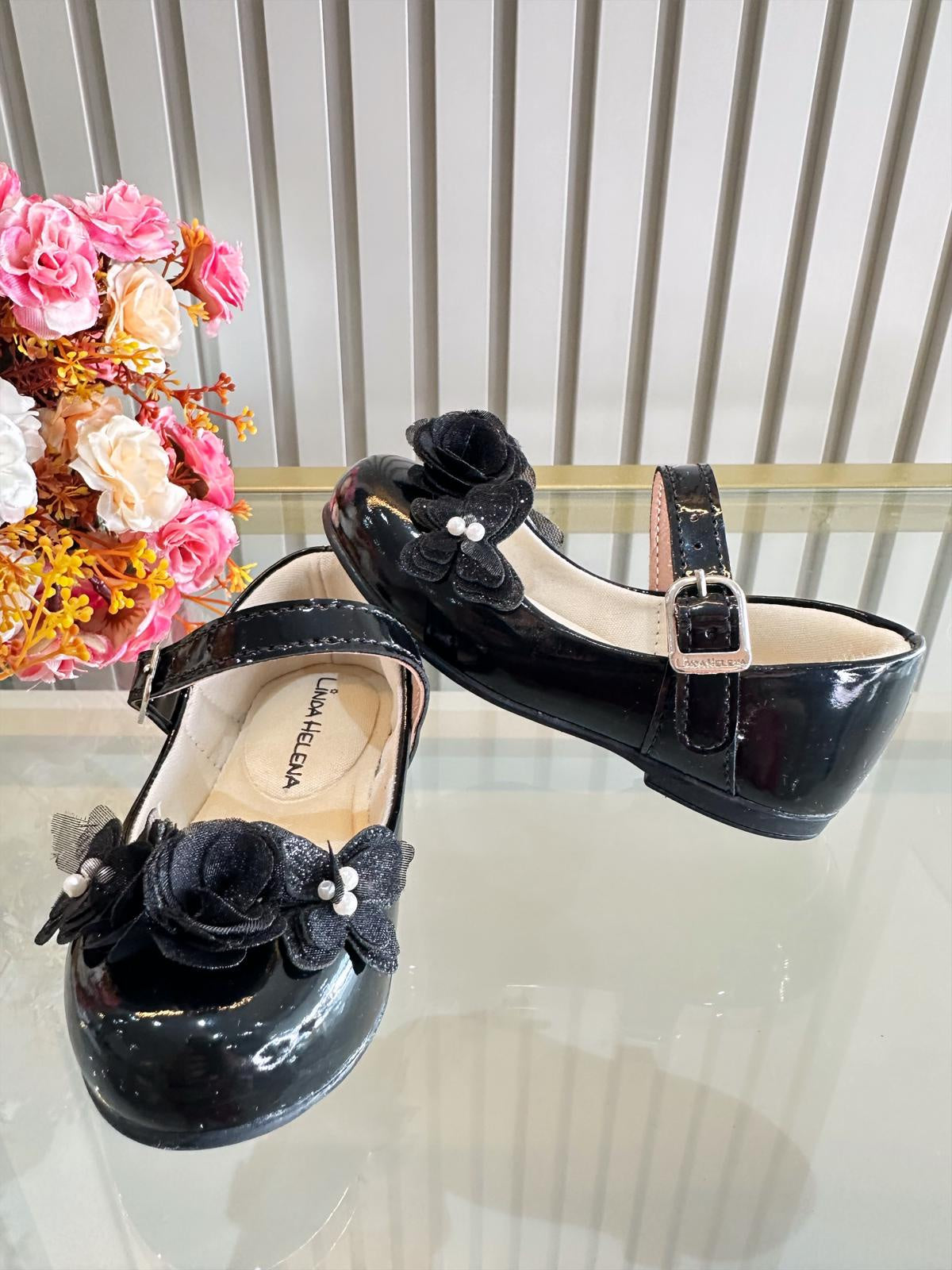 Zapatos infantiles de charol negro con aplique de mariposa y flor
