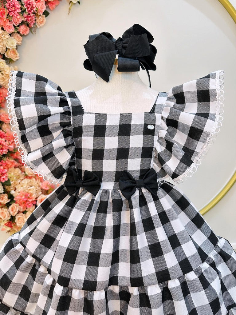 Vestido infantil a cuadros en blanco y negro con broche de lazo
