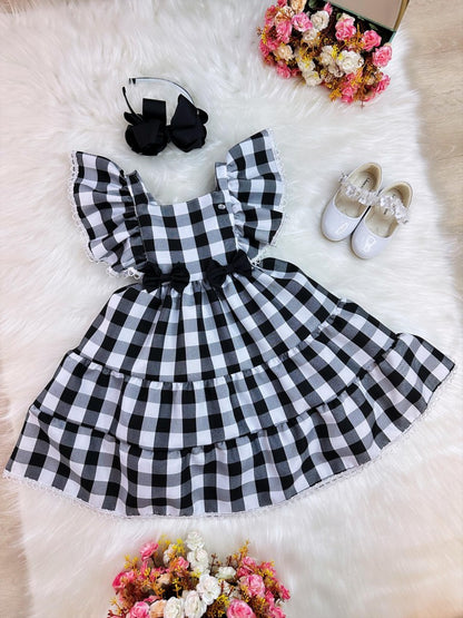Vestido infantil a cuadros en blanco y negro con broche de lazo