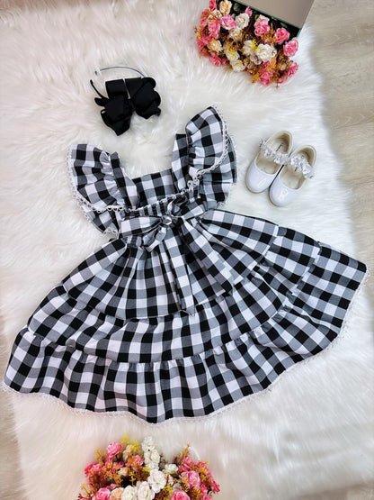 Vestido infantil a cuadros en blanco y negro con broche de lazo