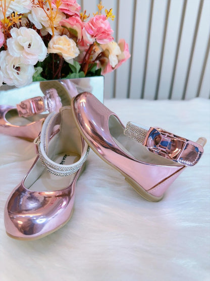 Zapato rosa metalizado con tiras de diamantes de imitación y aplique de lazo