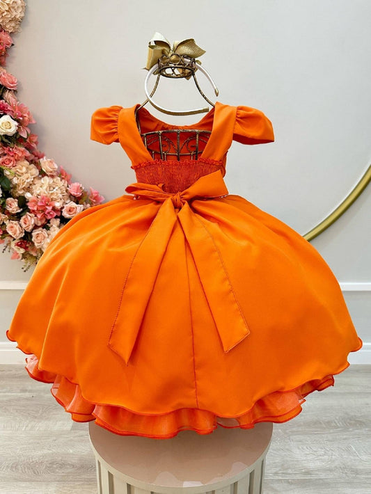 Vestido infantil de terracota con busto acanalado y cinturón de perlas