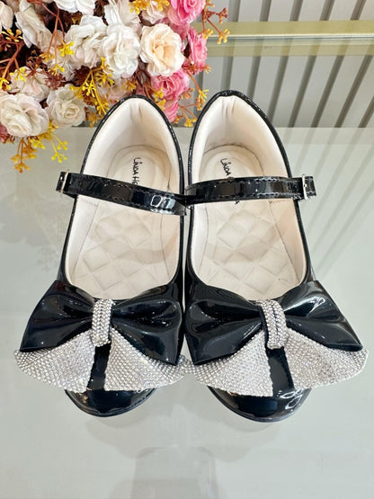 Zapatos infantiles de charol negro con aplique de lazo de diamantes de imitación 