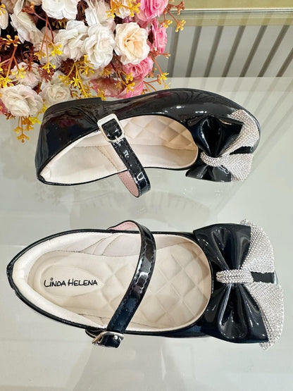 Zapatos infantiles de charol negro con aplique de lazo de diamantes de imitación 
