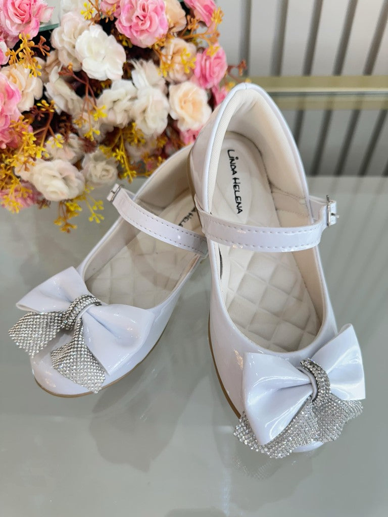 Zapatos infantiles de charol blanco con aplique de lazo de diamantes de imitación 