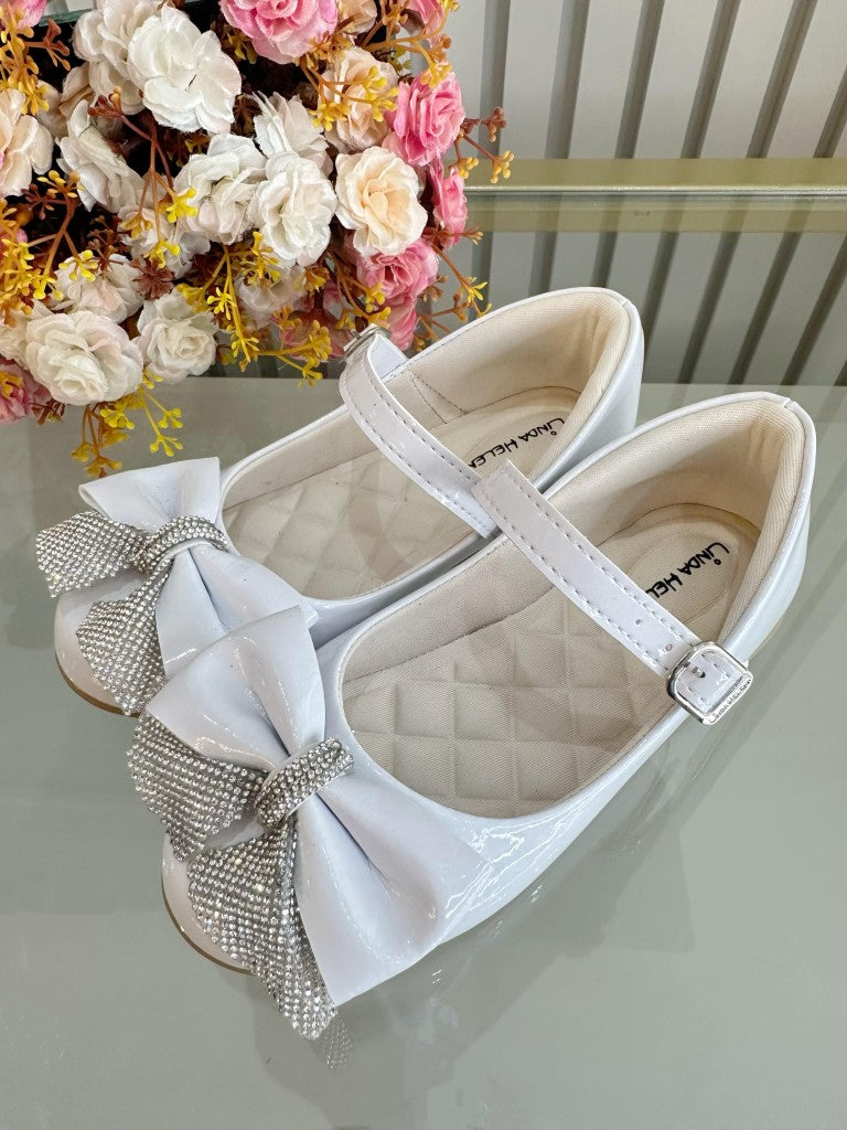 Zapatos infantiles de charol blanco con aplique de lazo de diamantes de imitación 