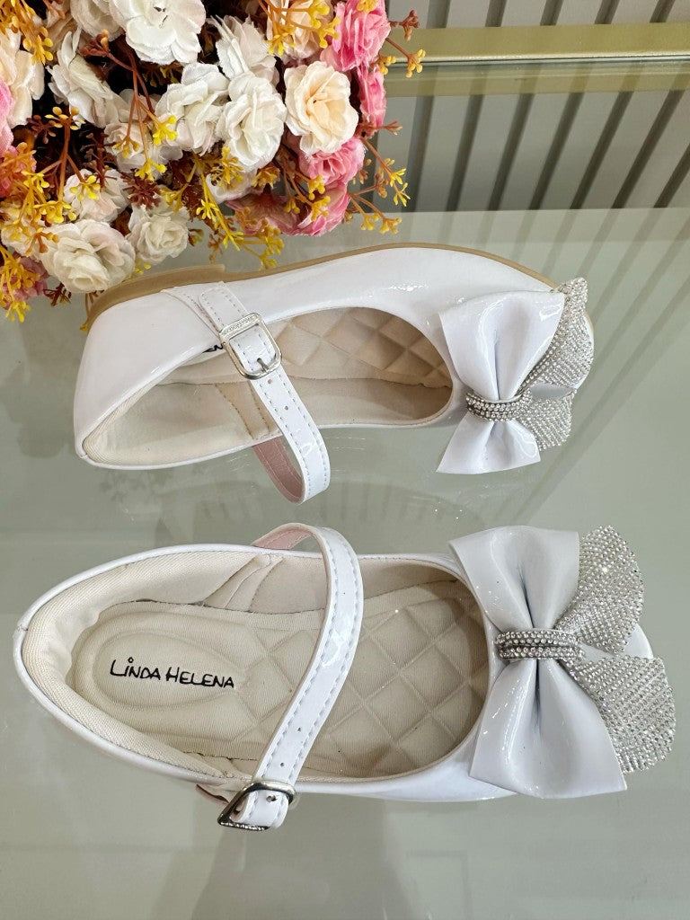 Zapatos infantiles de charol blanco con aplique de lazo de diamantes de imitación 
