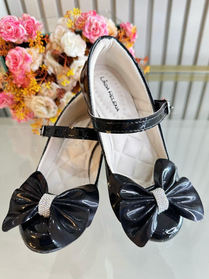 Zapato de tacón de charol negro con lazo y aplique de pedrería