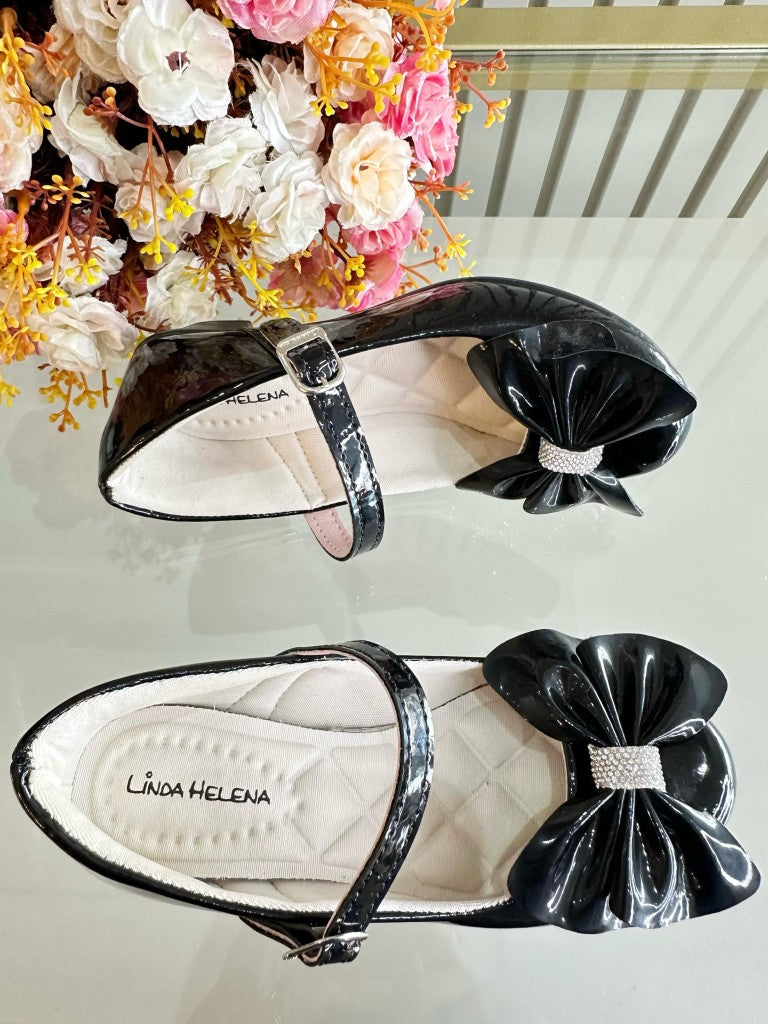 Zapato de tacón de charol negro con lazo y aplique de pedrería