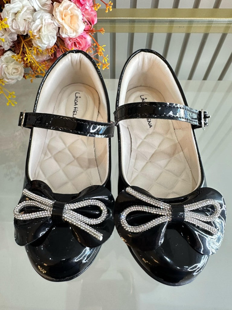 Zapatos infantiles de charol negro con lazo y aplique de pedrería