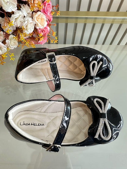 Zapatos infantiles de charol negro con lazo y aplique de pedrería